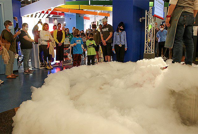 Children gather around a plume of smoke while celebrating the OH WOW Children's Center reopening.